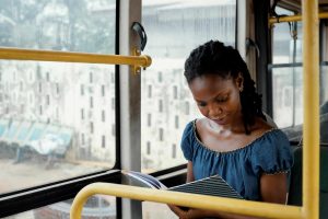 Medium-short-woman-reading-bus - Mkobo Bank